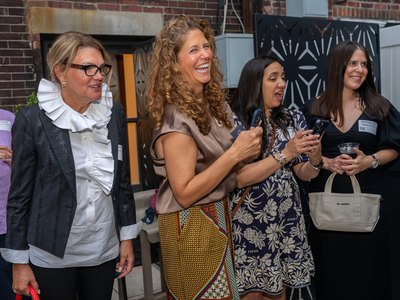 A group of guests in conversation across the showroom