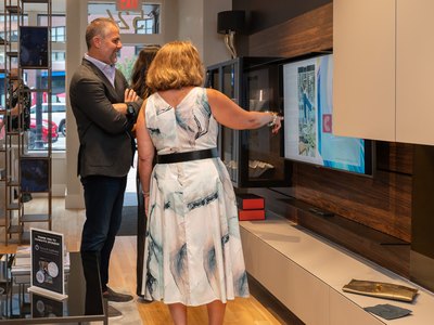 Two guests looking over a VETTii wall unit and its display screen