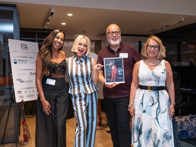 Four guests holding up the summer Kitchen & Bath issue of Reflections IN DESIGN at its launch